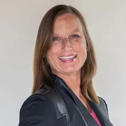 Lulu Waters PCC headshot photo, smiling woman with light brown hair and a dark blazer