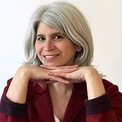 Alexis Niki ACC WPCC headshot photo, smiling woman with head resting on hands