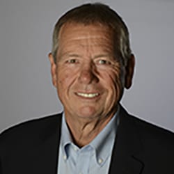 Charles Furman MS PCC headshot photo, smiling man in black blazer and light collared shirt in front of light gray background