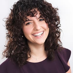Christina Stathopoulous PCC headshot photo, smiling woman with dark curly hair and dark purple top