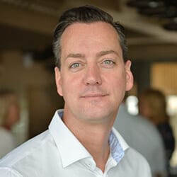 Scaba Csetneki PCC ACTC headshot photo, smiling man with dark hair wearing a white collared shirt