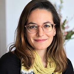 Emily Mitnick MCP ACC headshot photo, smiling woman with brown hair wearing glasses a yellow scarf and black blazer