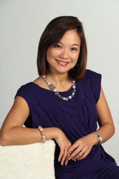 Dr Fenny Ang PCC ACC headshot photo, smiling woman with dark hair wearing purple dress in front of white background