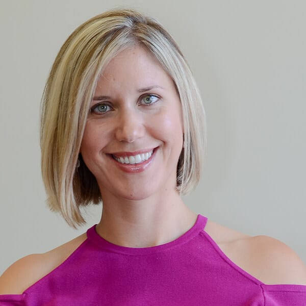 Dr. Jenna Filipkowski ACC headshot photo, smiling blond woman wearing a pink top in front of a light background
