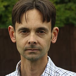 John Clapham PCC headshot, man with dark hair wearing a collared shirt outside
