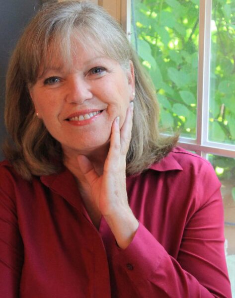 Kyle Dooley Kinder PCC headshot photo, smiling woman wearing red button up shirt in front of window