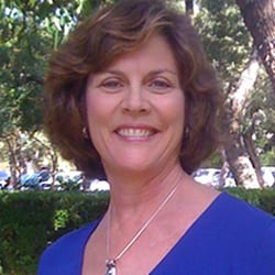 Dr. Linda Ford PCC headshot photo, smiling woman with brown hair wearing a blue top outside
