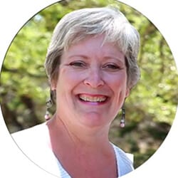 Marilyn Orr PCC headshot photo, smiling woman with gray hair wearing white top outside