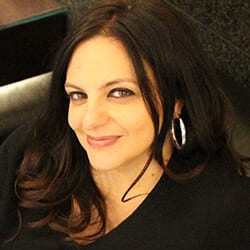 Rosa Edinga MBA CEC PCC headshot photo, smiling woman with dark hair wearing silver hoop earrings and a dark top
