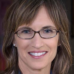 Tina Mertel MCC headshot photo, smiling woman wearing glasses with brown hair