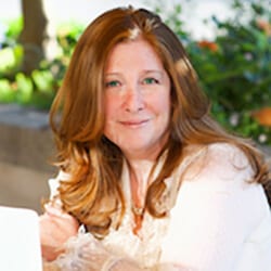 Lyssa Danehy deHart MCC MSW PCC headshot photo, smiling woman with red hair wearing white top outside