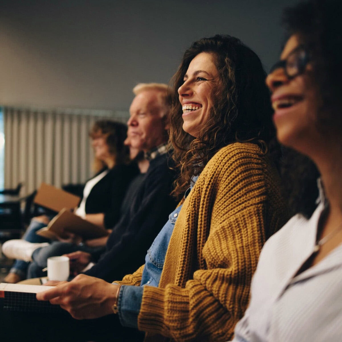 woman in focus smiling in a row at a class