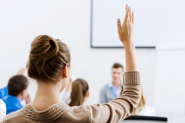 woman raising her hand, coaching school