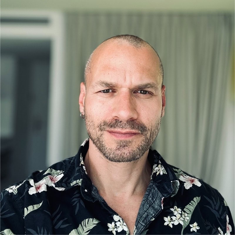 Rafal Szaniawski PCC headshot photo, man wearing dark floral shirt in front of neutral background