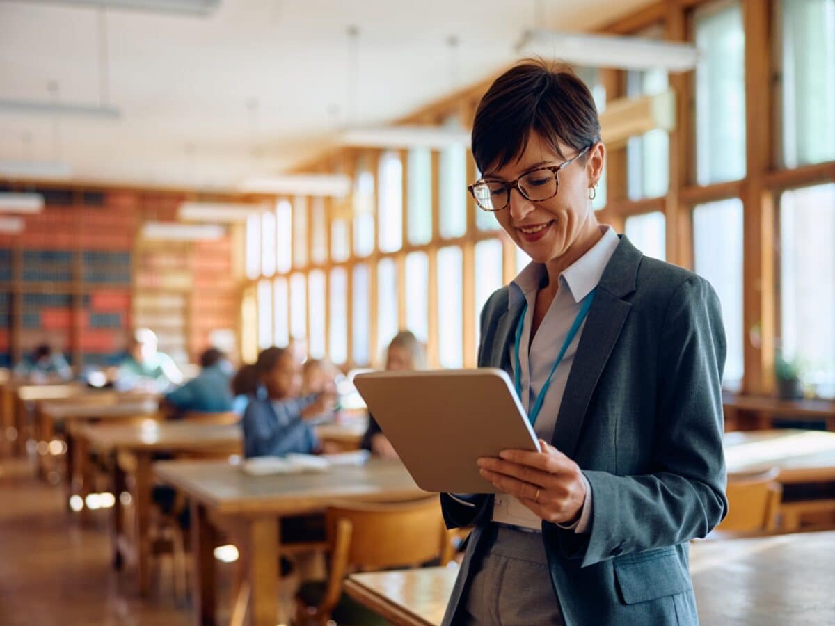 A women is reviewing the details of the research on a tablet in a classroom setting