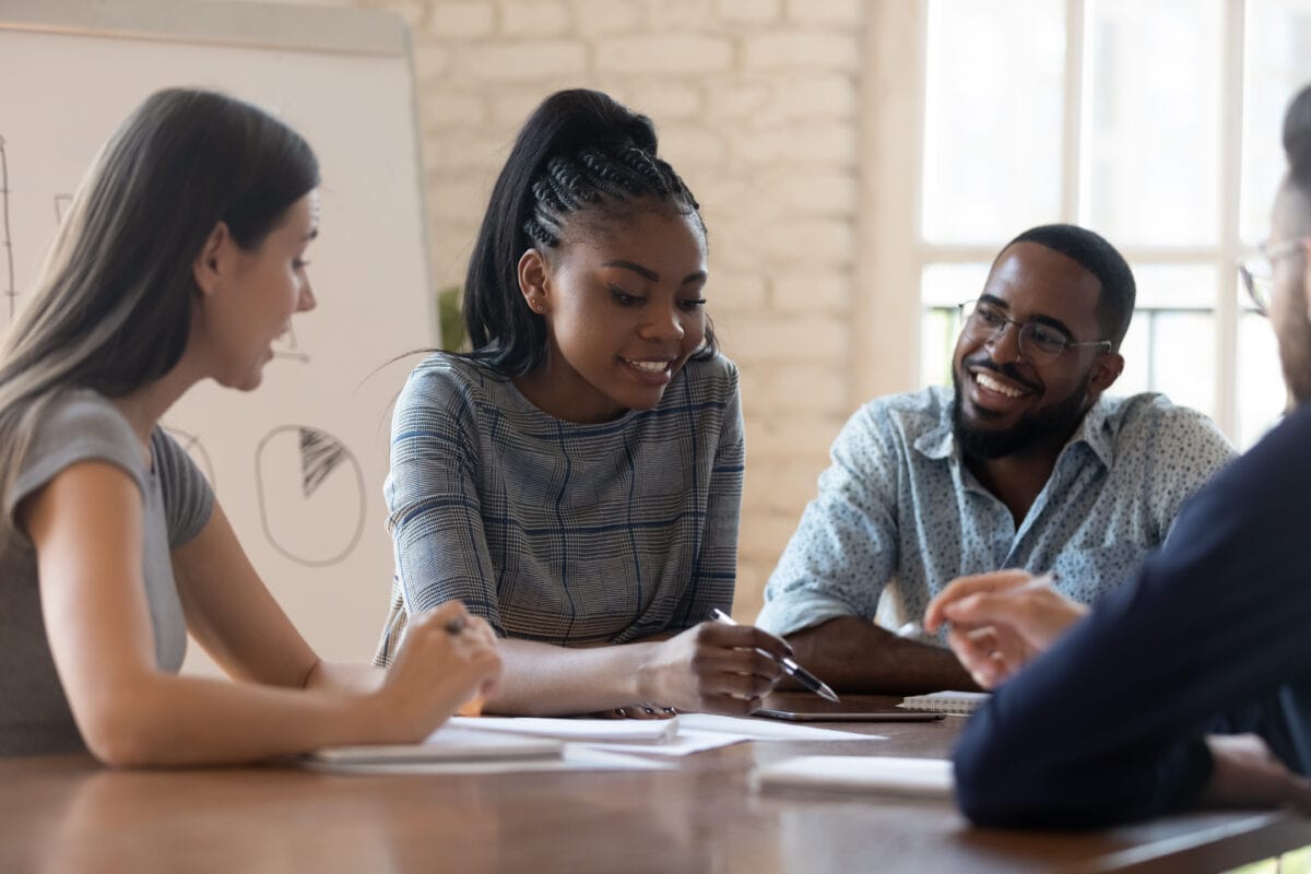 Small team gathered around a table discussing ideas during a business meeting