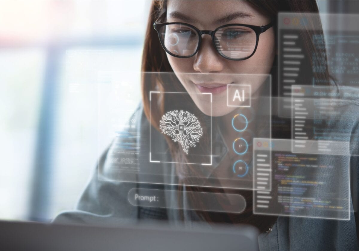 Woman using AI tools on a laptop with a holographic overlay
