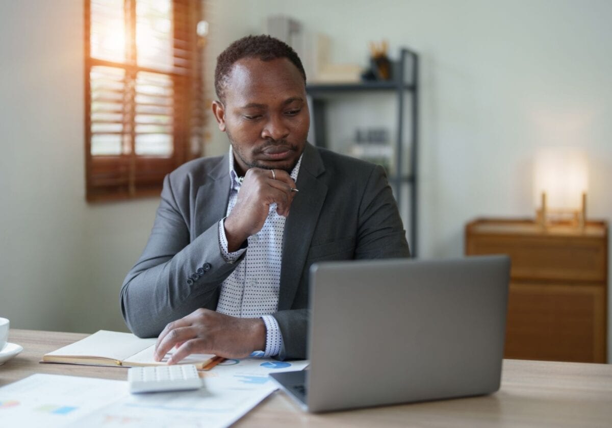 Man at his laptop, thoughtfully reviewing data and charts to improve his website