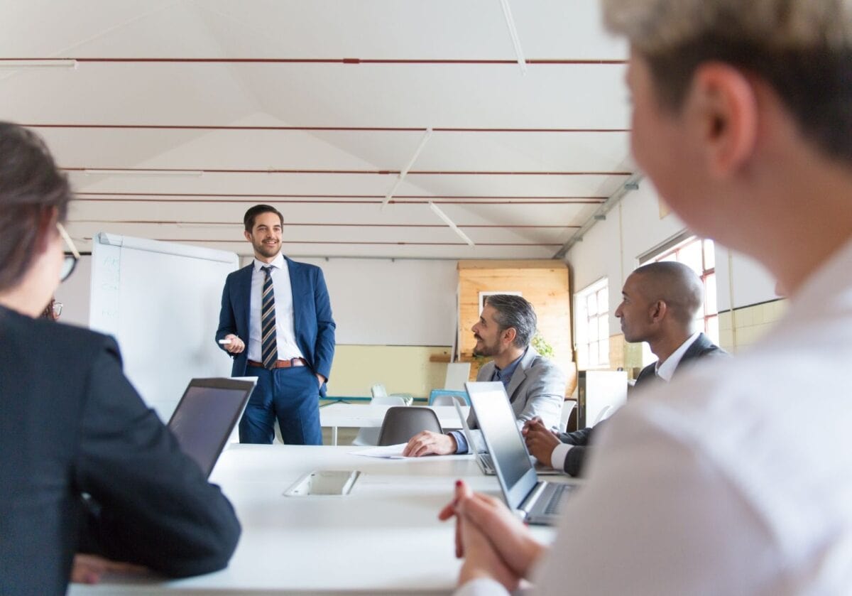 A business professional presenting to colleagues during a team meeting.