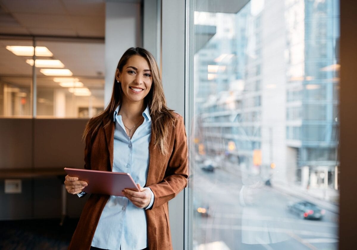 Smiling businesswoman holding a tablet in a modern office