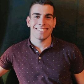 Panos Fragkos PCCh headshot photo, smiling man with dark polo in front of dark background
