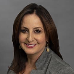 Ann Rindone PCC headshot photo, smiling woman with brown hair