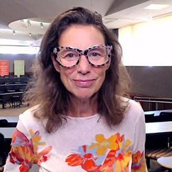 Julia Bafris McBridge PCC headshot photo, smiling woman with patterned glasses and sweater in an office