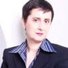 Maite Baron headshot photo, woman with short dark hair wearing blazer in front of white wall