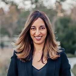 Manisha Dhawan ACC headshot photo, dark haired woman outside smiling