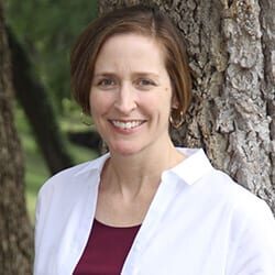 MaryAnn McKibben Dana ACC headshot photo, smiling woman with short brown hair wearing white collared shirt and maroon shirt outside