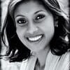 Racheal Govender headshot photo, smiling woman sitting wearing a blazer outside in black and white