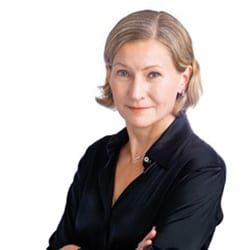 Rita Jupe ACC headshot photo, smiling woman with short blond hair standing with arms crossed