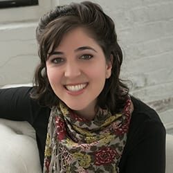 Talia Cooper ACC PCC headshot photo, smiling woman with dark hair sitting