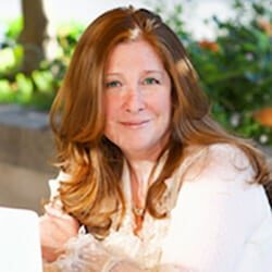 Lyssa Danehy deHart MCC MSW PCC headshot photo, smiling woman with red hair wearing white top outside