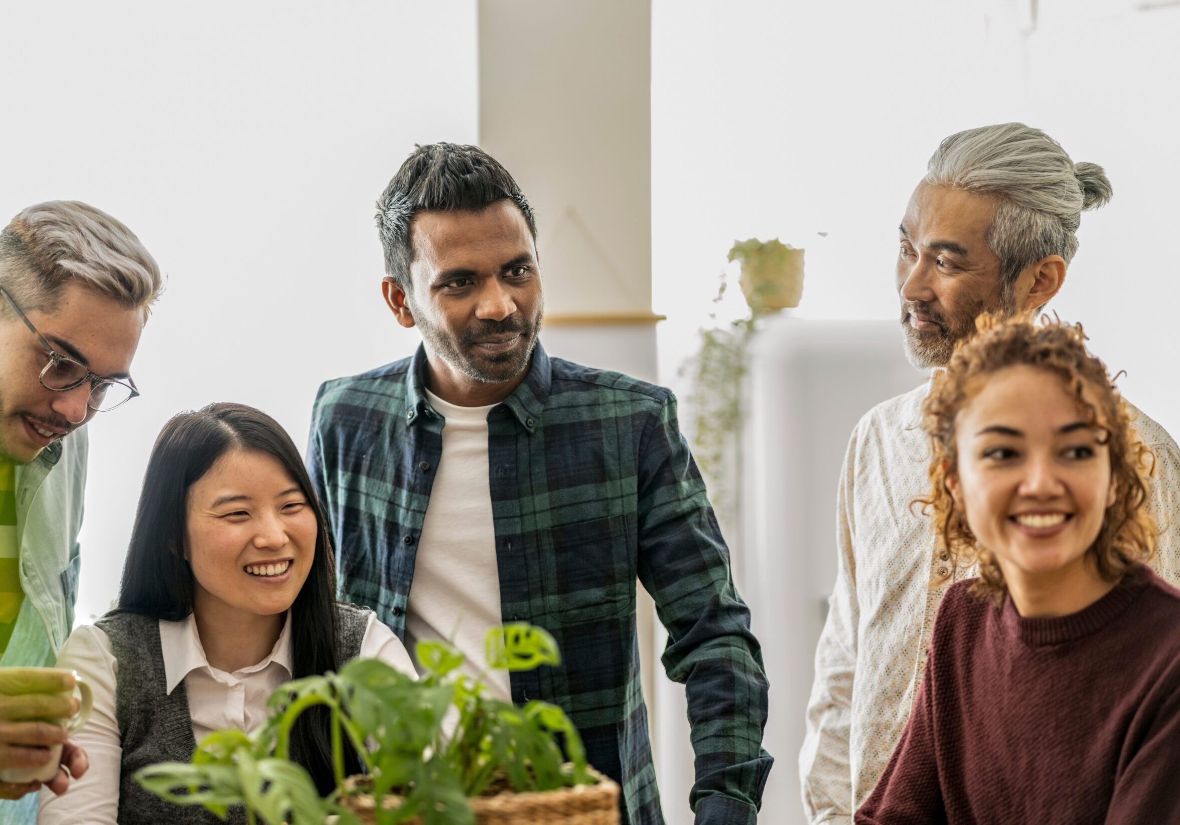 Group of all different individuals smiling in an office setting