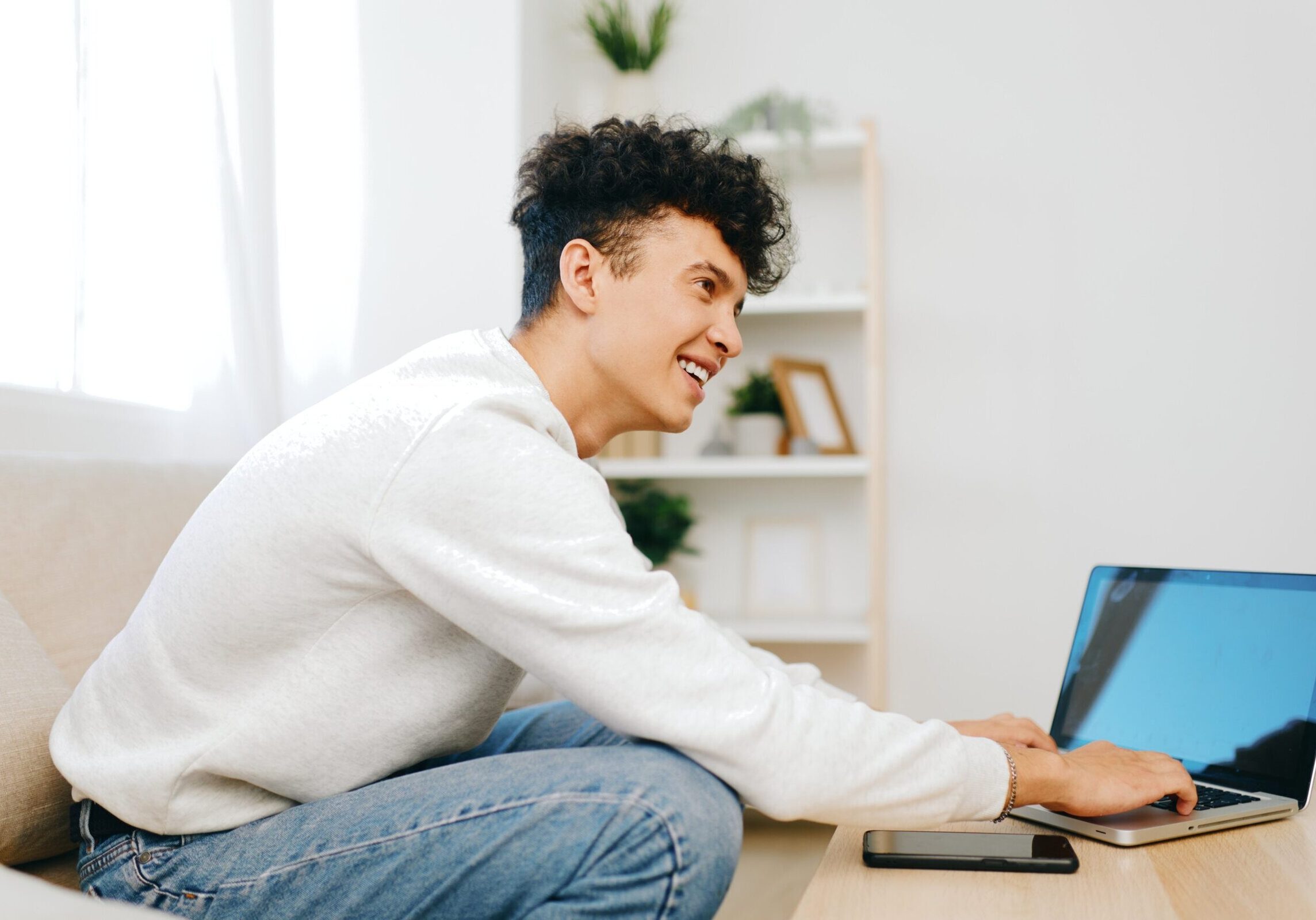 Smiling,Young,Man,Working,On,A,Laptop,At,Home,,Casual
