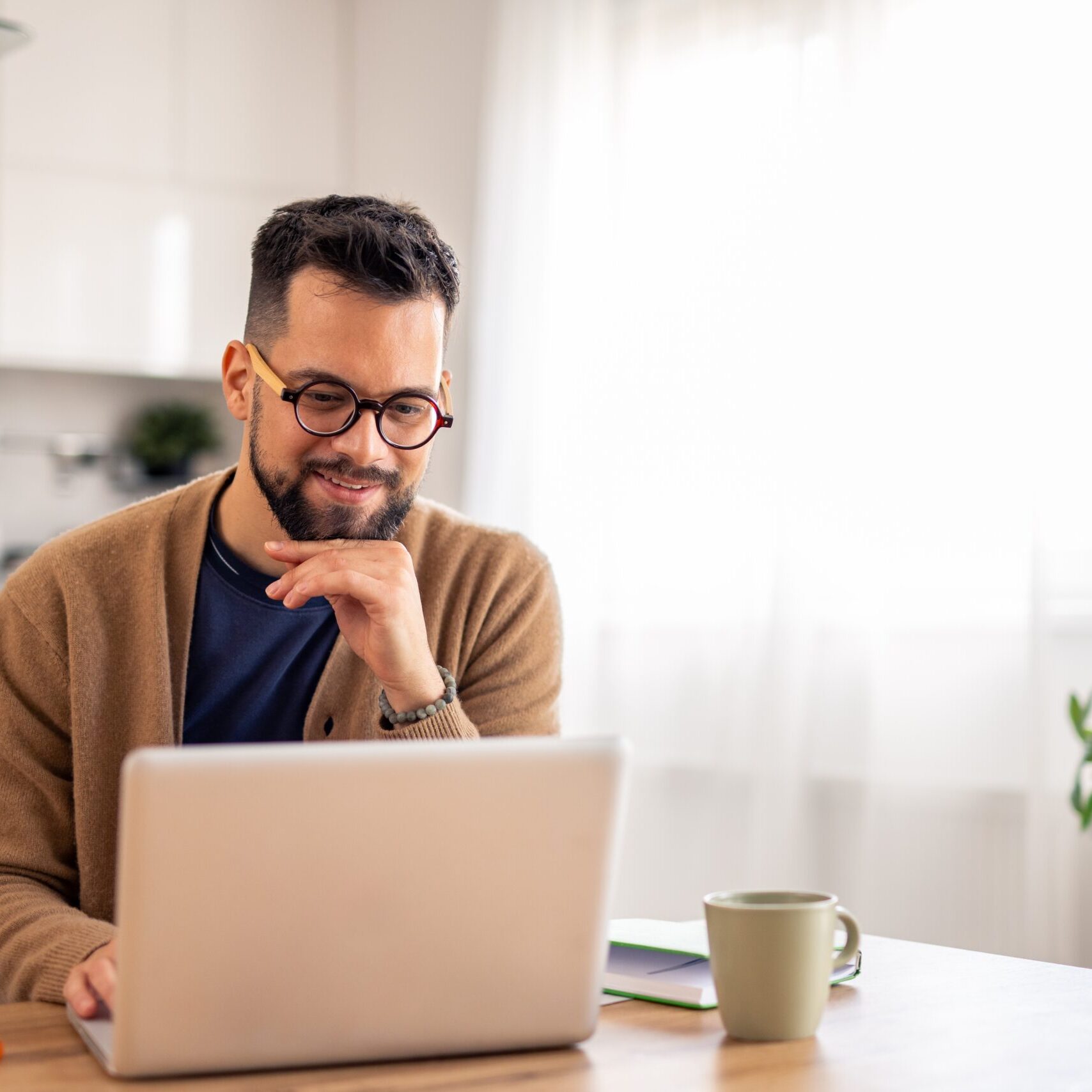 A man starring at a computer screen in his own home, prepared to start his own journey