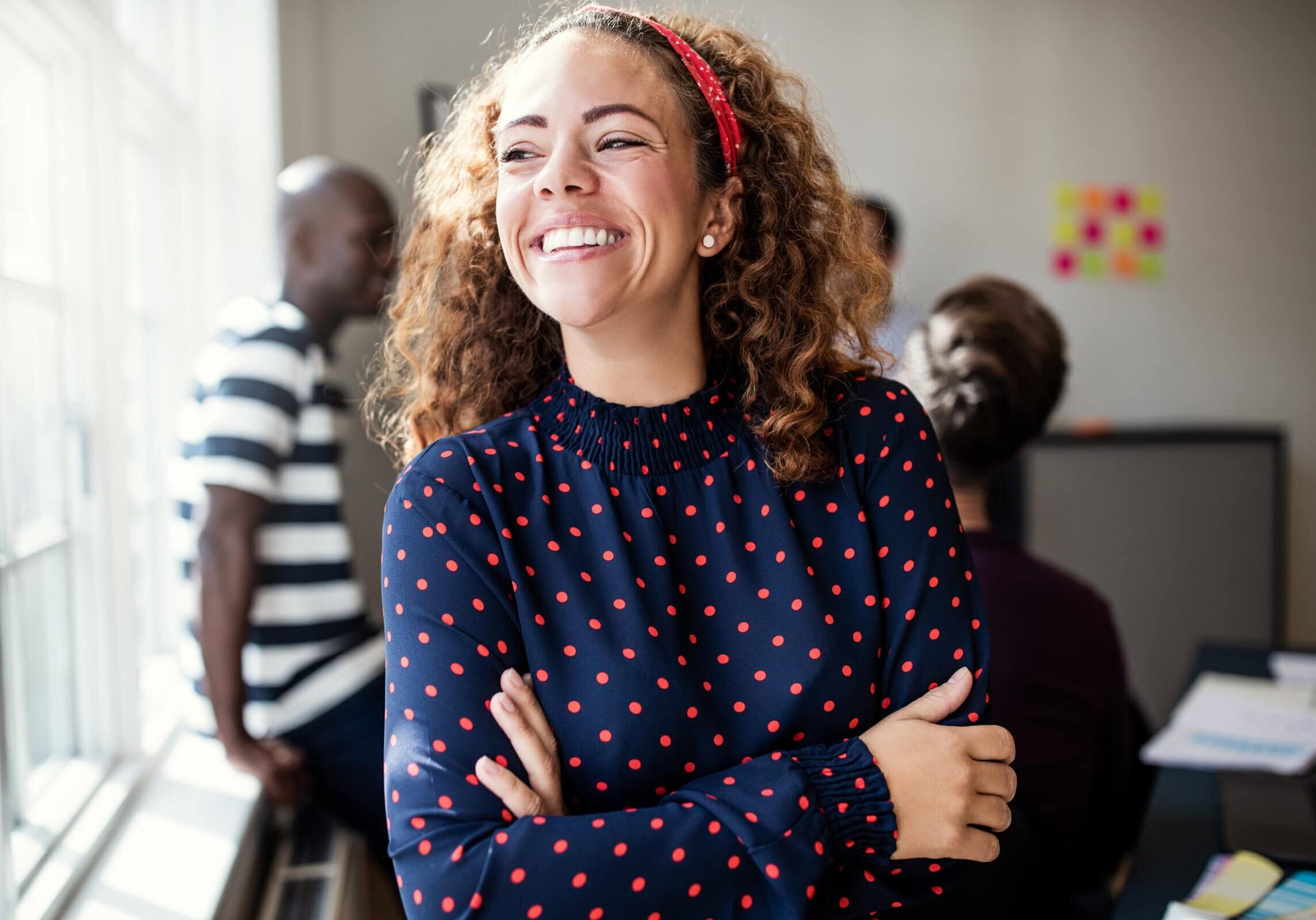 Laughing,Young,Female,Designer,Standing,With,Her,Arms,Crossed,In