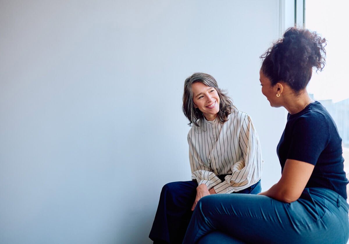 Two professionals engaged in a thoughtful coaching conversation.
