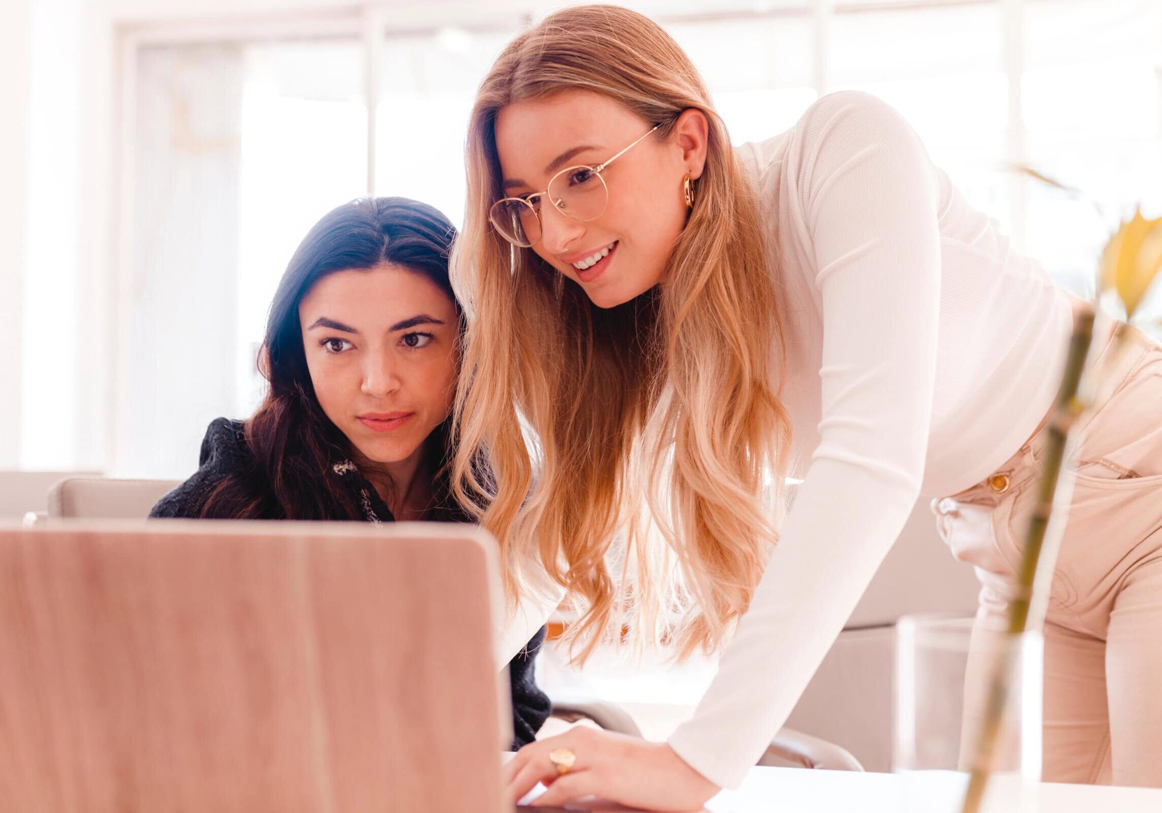 Two,Young,Women,Working,Together,With,Laptop,At,The,Office
