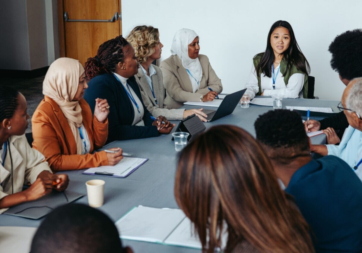 A diverse team of professionals, demonstrating cultural humility through active listening and shared dialogue.