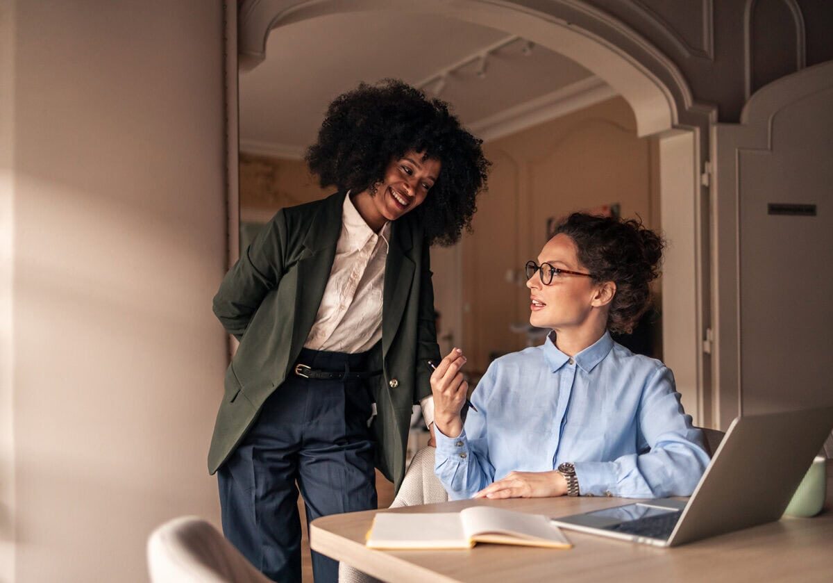 A diverse group of professionals in a modern workspace participating in a collaborative learning discussion, representing professional growth and continuous learning.