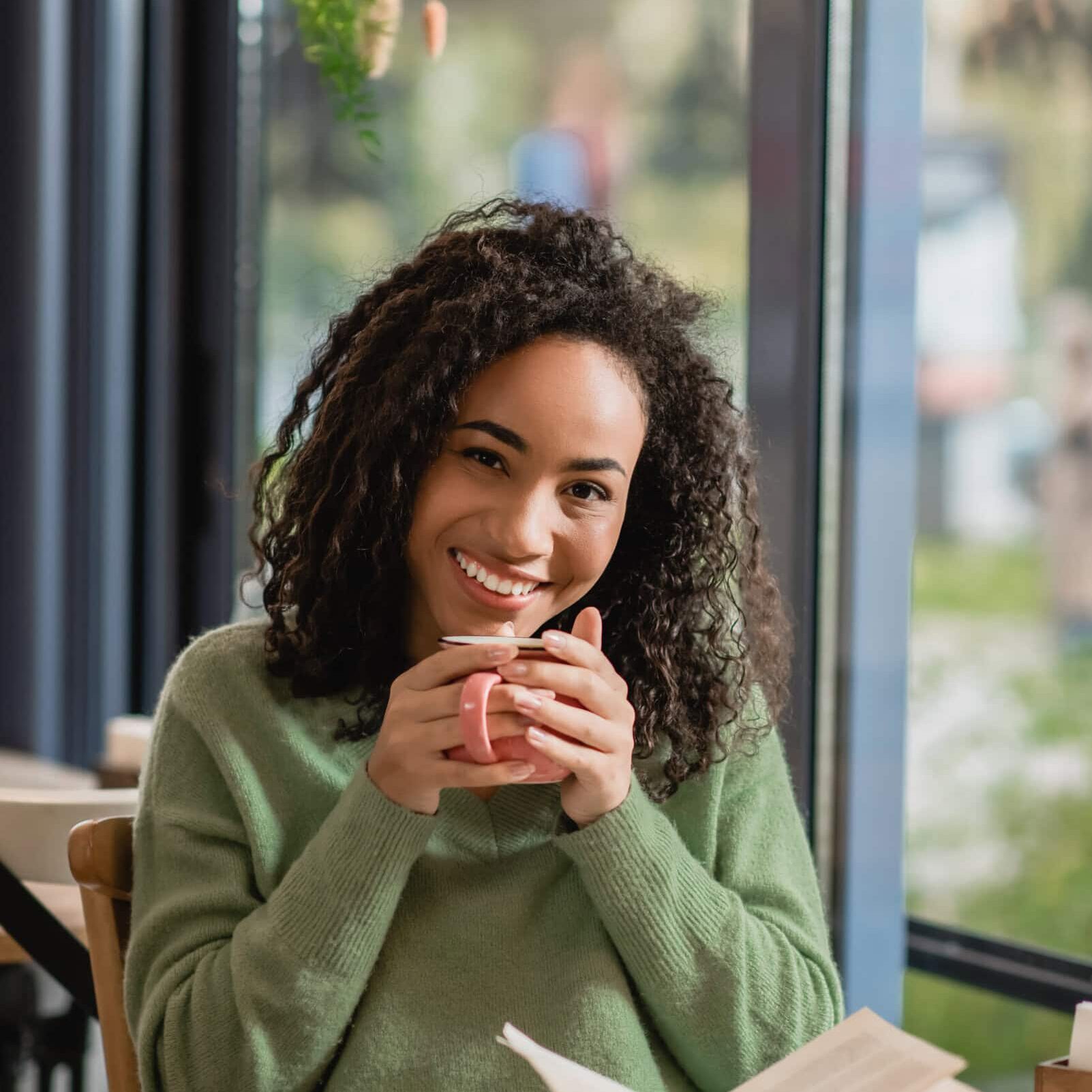 Happy,African,American,Woman,Holding,Cup,Of,Coffee,And,Looking