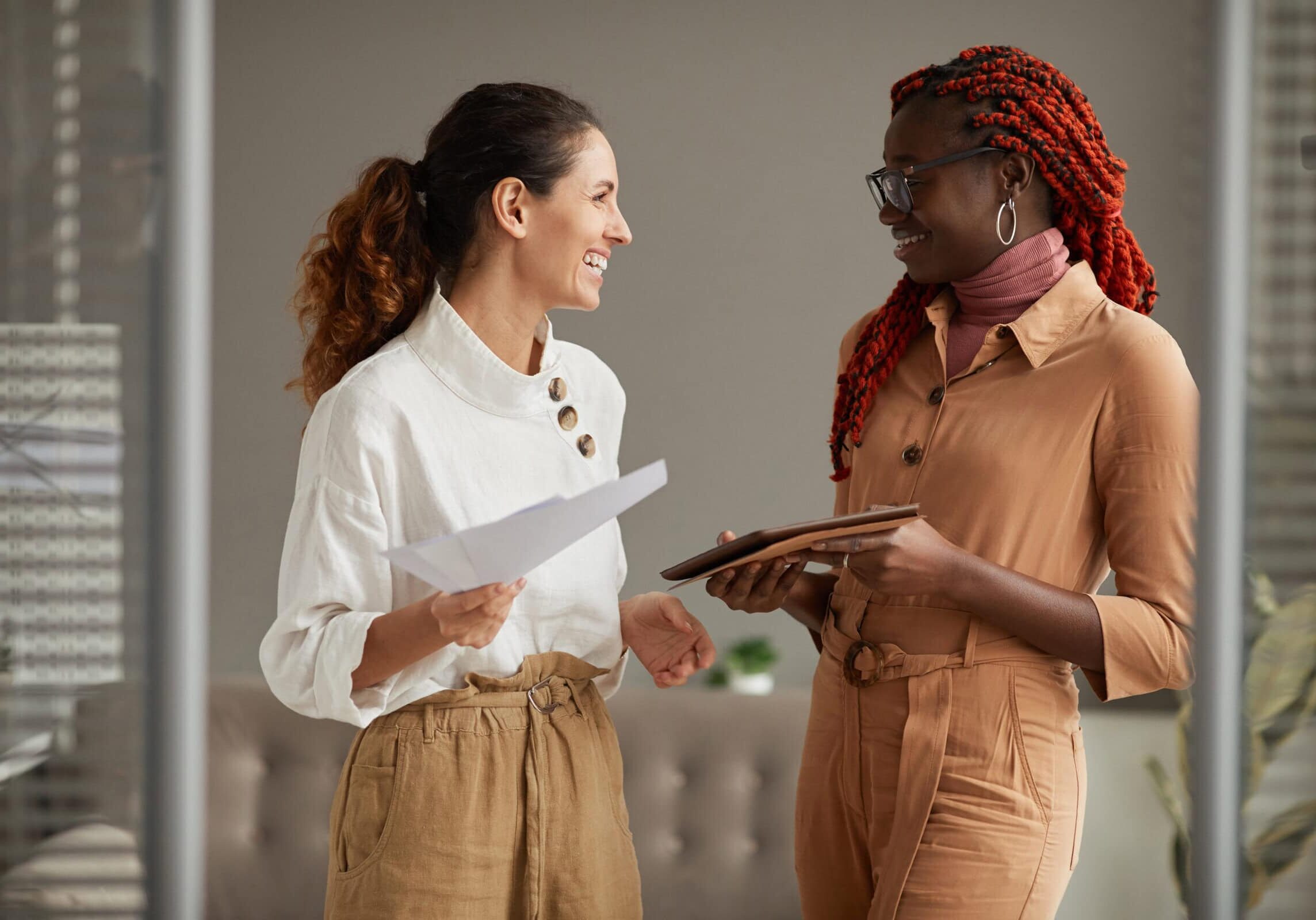Two woman standing in an office, one of the woman is coaching supervisor and the other is a coaching applicant.