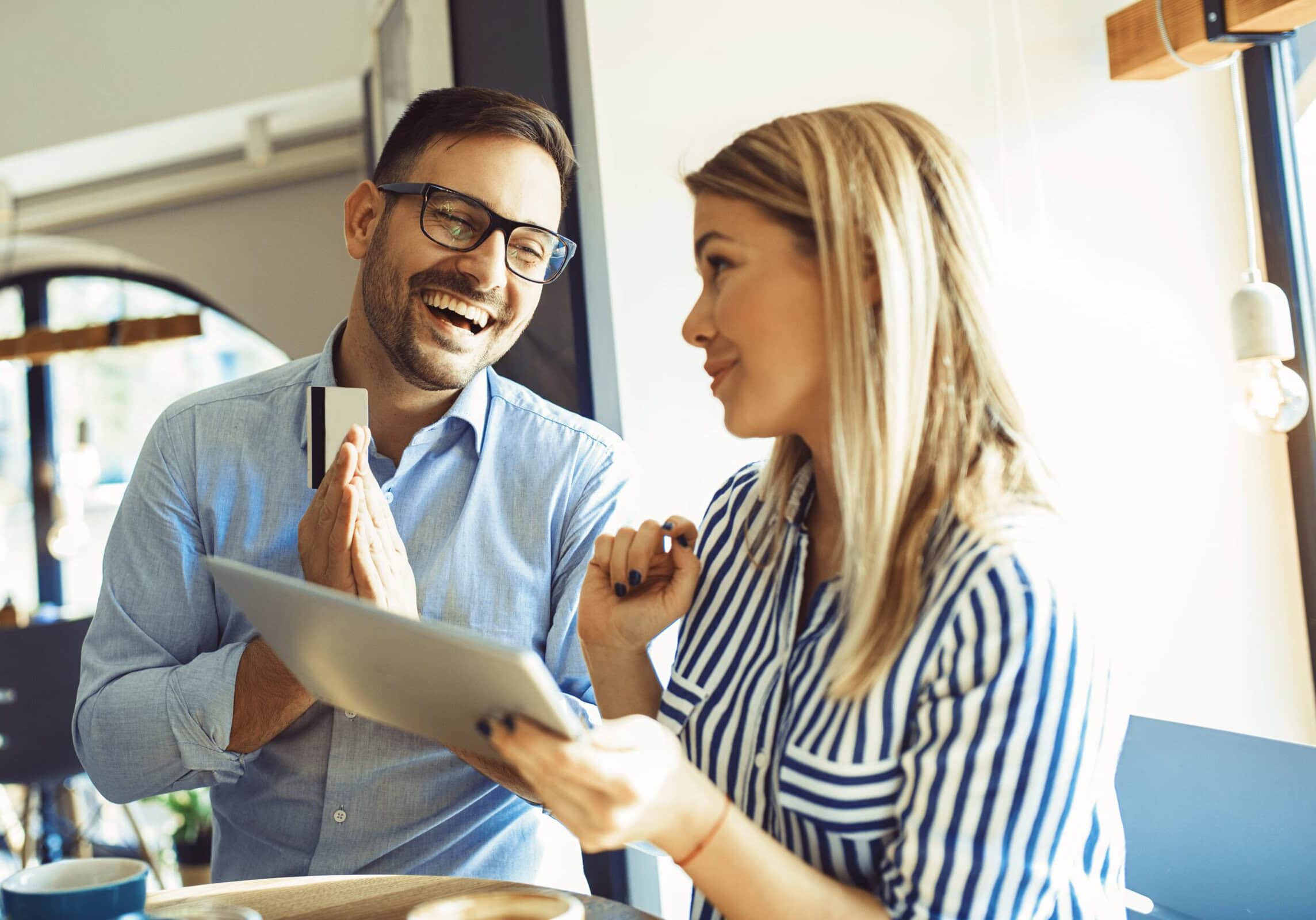 A man and woman are looking at a piece of paper, with one mentoring the other.